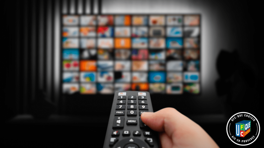 Personne tenant une télécommande face à un écran de streaming flou, avec le logo UFC Que Choisir Aix-en-Provence. Il peut être confronter à des pratiques publicitaires abusive.