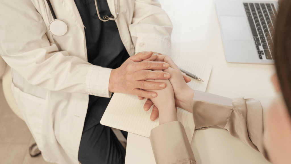 Professionnel de santé tenant les mains d’un patient, illustrant l’écoute et l’accompagnement des Représentants des Usagers.